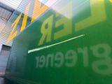 a green and yellow sign that says leer greenner