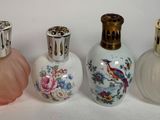 Plusieurs types de flacons de parfum sont alignés sur une surface blanche