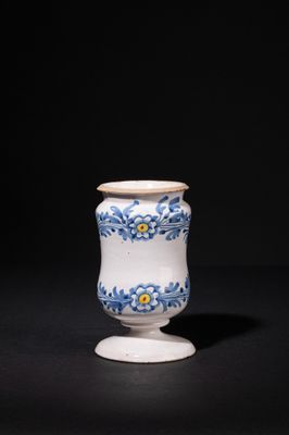 a white and blue vase sitting on top of a black table