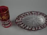 a red glass plate and a red glass cup on a table