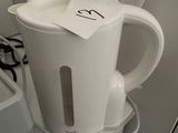 a white kettle sitting on top of a counter next to a blender