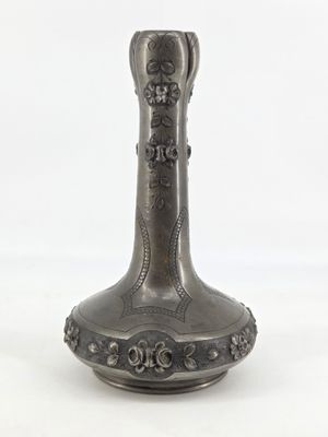 a silver vase sitting on a white surface with a white background