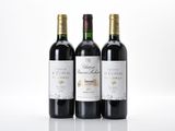 three bottles of red wine sitting on top of a white table