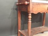 a small wooden table with a mirror on top of it
