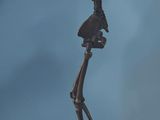 statue of a skeleton holding a baseball bat on a wooden base
