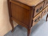 a small wooden table with drawers on it