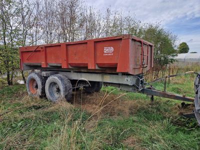 un camion-benne rouge garé dans l'herbe