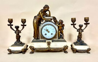 a clock sitting on top of a table next to three candles