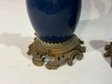 a blue vase sitting on top of a table next to two other vases