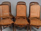 four chairs with wicker seats and wooden legs on a grey background