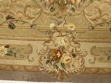 a close up of a rug with flowers and birds on it