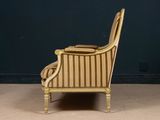 an antique gold striped chair against a dark blue wall