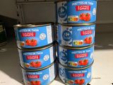 several tins of tomatoes are stacked on a shelf in a store