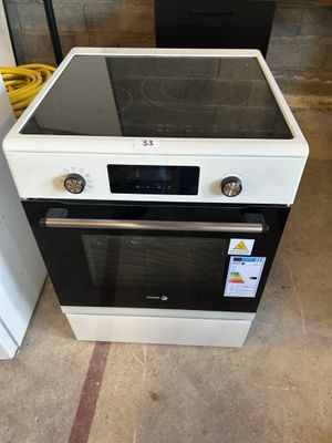 une cuisinière blanche avec un plan de cuisson noir et un four blanc