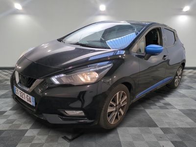 la voiture noire est garée sur un sol en damier dans le garage