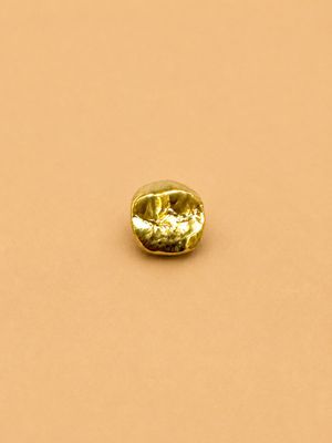un diamant jaune sur une surface beige clair