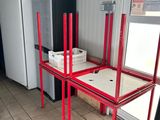 a red table with a tv on it in the corner of a room