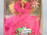 doll in a pink dress in a box with a star on top