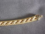 a close up of a gold colored bracelet on a gray surface