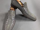 a pair of gray shoes with a brown sole on a gray surface