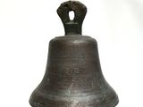 a metal bell that is sitting on a white surface