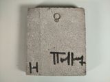 a cement plaque with the word h written on it