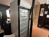 a refrigerator that is sitting in a room with papers on the floor