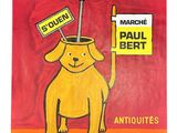yellow dog holding a sign that says les puces and a red background
