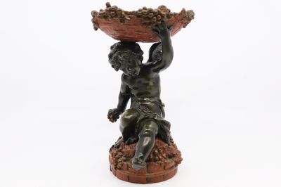 une image représentant la statue d'un garçon tenant un bol sur la tête
