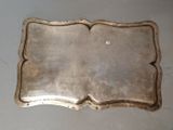 an antique silver plate with a decorative edge on a table