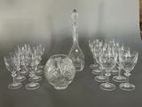 a lot of wine glasses and a decanter on a table