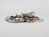 a close up of a pile of assorted jewelry on a white surface