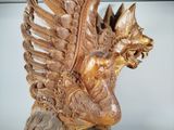 a wooden statue of a winged horse with wings on it ' s head