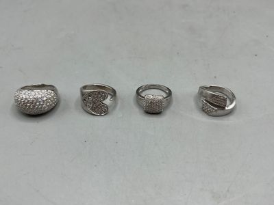quatre bagues en argent sur une surface blanche, sur fond blanc