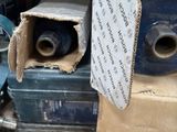 une boîte remplie de rouleaux de ruban adhésif bleu, à côté d'autres rouleaux de ruban adhésif bleu