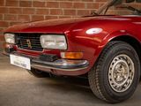 a red car parked in front of a brick wall