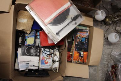 une boîte remplie de livres et de DVD posée par terre