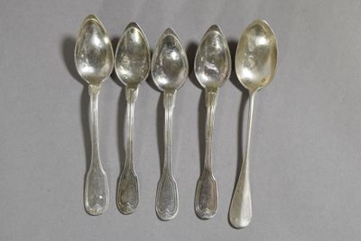six cuillères sont alignées sur une table