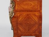 a small wooden cabinet with a marble top on wheels