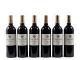 four bottles of red wine are lined up on a white surface