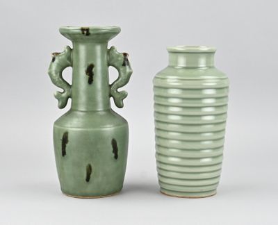 deux vases verts posés l'un à côté de l'autre sur une table