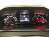 the dashboard of a car with a red light on it ' s gauges