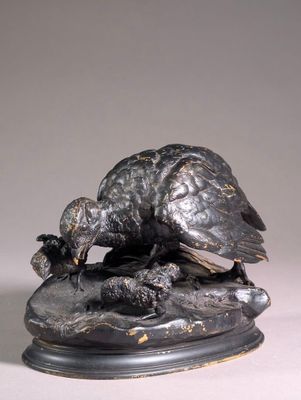 bronze statue of a bird on a rock with a bird on it ' s back