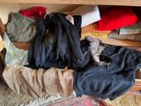 a dog that is laying on a pile of clothes