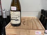 une caisse en bois sur laquelle est posée une bouteille de vin
