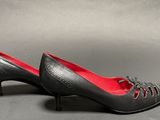 a pair of women ' s black shoes with red soles
