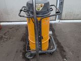 a yellow and black vacuum on a cart in front of a building
