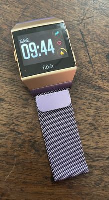 une photo d'une montre connectée posée sur une table en bois