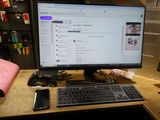 un écran d'ordinateur posé sur un bureau, à côté d'un clavier