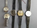 several different types of watches sitting on top of a table